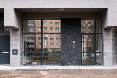 Bezpečné vstupní dveře bytového domu s kvalitním materiálem a zabezpečením proti neoprávněnému vstupu.